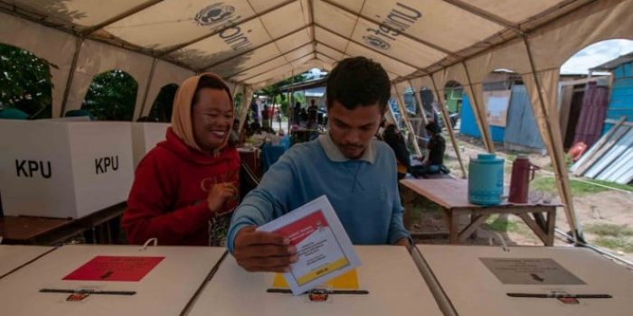 Seorang warga korban bencana memasukkan surat suara ke kotak suara usai menyalurkan hak suaranya di tenda pengusian saat pemungutan suara Pemilu 2019, di TPS 01 Kelurahan Petobo , Palu, Sulawesi Tengah