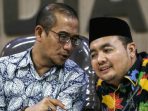 Komisioner Bawaslu Muhammad Afifudin (kanan) berbincang dengan Komisioner KPU Hasyim Asyari (kiri) saat konferensi pers terkait dugaan surat suara tercoblos di Malaysia di Jakarta,