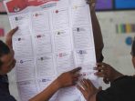 Petugas KPPS memperlihatkan suara Pemilu 2019.
