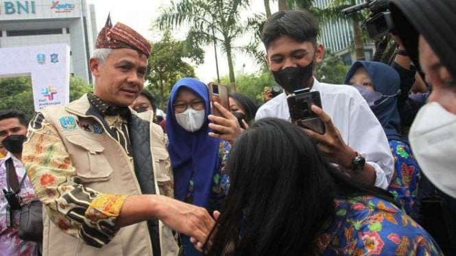 Gubernur Jawa Tengah Ganjar Pranowo (kiri) menyapa warga saat menghadiri Road to Hakordia (Hari Antikorupsi Sedunia) di Alun-Alun Surabaya, Jawa Timur, Kamis, 1 Desember 2022.