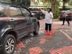 Menteri Sosial Tri Rismaharini mencuci mobil.