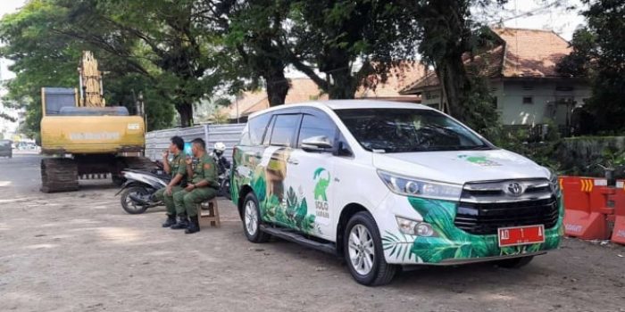 Dua petugas Linmas menjaga mobil dinas Wali Kota Solo Gibran Rakabuming Raka yang diparkirkan di di sebelah barat proyek pelebaran Viaduk Gilingan, Banjarsari, Solo, Jawa Tengah, Rabu sore, 26 April 2023.
